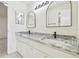 Bathroom vanity features dual undermount sinks, granite countertops, and a mirror with sconce lighting at 9473 N Forest Hills Pl, Tampa, FL 33612