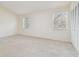 Bedroom featuring neutral carpet, two windows for natural light, and a closet at 9473 N Forest Hills Pl, Tampa, FL 33612