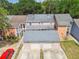View of three homes featuring multiple garages and tree-lined street at 9473 N Forest Hills Pl, Tampa, FL 33612
