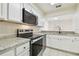 Bright kitchen with stainless steel appliances, granite countertops, and white cabinets at 9473 N Forest Hills Pl, Tampa, FL 33612