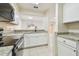 Bright kitchen with stainless steel appliances, granite countertops, and white cabinets at 9473 N Forest Hills Pl, Tampa, FL 33612