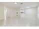 Spacious living room with neutral tile flooring and a view into the kitchen at 9473 N Forest Hills Pl, Tampa, FL 33612