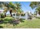 Charming home exterior with lush lawn, landscaping, and beautiful tropical palm trees at 9690 41St N St # 0, Pinellas Park, FL 33782