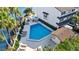 Aerial view of community pool with lounge chairs, tables, palm trees, and lush landscaping at 101 Marina Del Rey Ct, Clearwater, FL 33767