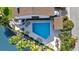Aerial view of community pool with lounge chairs, tables, palm trees, and lush landscaping at 101 Marina Del Rey Ct, Clearwater, FL 33767
