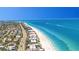 Aerial view of the beach and surrounding real estate with a clear blue sky at 101 Marina Del Rey Ct, Clearwater, FL 33767
