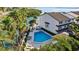 Aerial view of community pool with lounge chairs, tables, palm trees, and lush landscaping at 101 Marina Del Rey Ct, Clearwater, FL 33767
