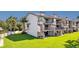 Exterior shot of canal-front townhome with balconies, stairs, solar panels and a lush green lawn at 101 Marina Del Rey Ct, Clearwater, FL 33767
