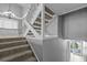 Well-lit staircase with carpeted steps, white railing, and views into the adjacent living spaces at 101 Marina Del Rey Ct, Clearwater, FL 33767