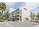 Modern building exterior with a vibrant red accent and surrounding palm trees in an urban setting at 101 N 12Th St # 400, Tampa, FL 33602