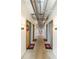 Hallway with exposed industrial pipe features and unit numbers on doors, creating an urban aesthetic at 101 N 12Th St # 400, Tampa, FL 33602
