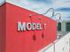 Close-up of 'MODEL T' signage mounted on a bright red wall with stylish lighting at 101 N 12Th St # 400, Tampa, FL 33602