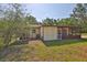 Property backyard showing home's rear, with trees, lawn, and utility equipment at 1019 Lakeside Dr, Seffner, FL 33584