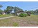 Home's backyard showcasing lawn, mature plantings, trees, and a screened porch at 1019 Lakeside Dr, Seffner, FL 33584