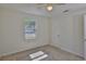 Cozy bedroom featuring neutral carpet, bright window, and ceiling fan at 1019 Lakeside Dr, Seffner, FL 33584