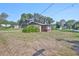 Exterior view of home with lawn, plantings, mature trees, and a screened porch at 1019 Lakeside Dr, Seffner, FL 33584