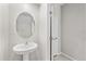 A pedestal sink with an oval mirror, next to the door of a half bathroom with tile floors at 10472 Shady Preserve Dr, Riverview, FL 33578