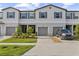 Charming townhouse featuring a two-car garage, landscaped front yard, and neutral color palette at 10472 Shady Preserve Dr, Riverview, FL 33578