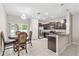 Open-concept kitchen with dark cabinets, stainless steel appliances, granite countertops, and a chandelier-lit dining area at 10472 Shady Preserve Dr, Riverview, FL 33578