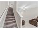 View of carpeted staircase leading to a bonus room with a ceiling fan and a plush recliner chair at 10472 Shady Preserve Dr, Riverview, FL 33578