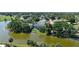 Aerial view of a blue home on the water surrounded by trees and other houses in the neighborhood at 10775 Glen Ellen Dr, Tampa, FL 33624