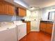Laundry room with a bathroom featuring a shower, updated vanity, washer, dryer, and storage cabinets, maximizing functionality at 10775 Glen Ellen Dr, Tampa, FL 33624