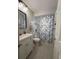 Cozy bathroom with grey walls, tub with floral shower curtain and modern vanity at 10775 Glen Ellen Dr, Tampa, FL 33624