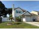 Inviting two-story home with a manicured lawn, small palm tree, and turquoise door and shutters at 10775 Glen Ellen Dr, Tampa, FL 33624