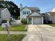 Charming two-story home featuring a well-maintained lawn, white picket fence, and colorful turquoise accents at 10775 Glen Ellen Dr, Tampa, FL 33624