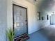 Exterior shot of a light blue front door with silver hardware, framed by a welcome mat and greenery at 10800 Us Highway 19 N # 127, Pinellas Park, FL 33782
