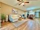 Open-concept living room with wood floors and ample natural light, seamlessly flowing into dining area at 10800 Us Highway 19 N # 127, Pinellas Park, FL 33782