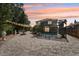 Backyard view featuring a screened-in pool, statues, a patio, a water feature, lush greenery, and an atmospheric sunset at 11029 Lynn Lake Cir, Tampa, FL 33625