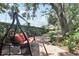 A tranquil backyard swing hanging beneath mature trees, offering a peaceful escape, with a brick path leading to the house at 11029 Lynn Lake Cir, Tampa, FL 33625