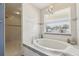 Bright bathroom features a soaking tub beneath a window, complemented by a tiled walk-in shower at 11029 Lynn Lake Cir, Tampa, FL 33625