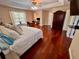 Bright main bedroom with hardwood floors, a ceiling fan, a tv, and view of an office space at 11029 Lynn Lake Cir, Tampa, FL 33625