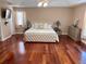 Spacious main bedroom with hardwood floors, neutral walls, tray ceilings, and a tufted headboard at 11029 Lynn Lake Cir, Tampa, FL 33625