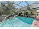 View of the screened-in pool area showcasing a water feature, outdoor seating, and a grill with food preparation area at 11029 Lynn Lake Cir, Tampa, FL 33625