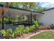 Charming covered porch with a ramp, complemented by vibrant foliage and lush landscaping at 1128 S 70Th St, Tampa, FL 33619