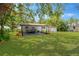 Spacious backyard featuring a covered patio and lush lawn, perfect for outdoor living and entertaining at 1128 S 70Th St, Tampa, FL 33619