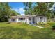 Charming white brick home with a well-manicured front yard and beautiful landscaping at 1128 S 70Th St, Tampa, FL 33619