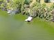 Aerial view showcasing the dock with boat lift, lush trees, and waterfront scenery from an elevated perspective at 11921 Fort King Hwy, Thonotosassa, FL 33592