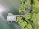Aerial view of a covered dock featuring boat lifts in a serene, tree-lined waterfront setting at 11921 Fort King Hwy, Thonotosassa, FL 33592