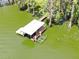 Overhead view displays the boat dock with boat lift amidst the green trees and water landscape at 11921 Fort King Hwy, Thonotosassa, FL 33592