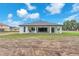 Modern white home with a covered patio and black trim windows in a spacious backyard at 11921 Fort King Hwy, Thonotosassa, FL 33592