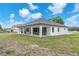 Modern white home with a covered patio and black trim windows in a spacious backyard at 11921 Fort King Hwy, Thonotosassa, FL 33592