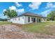 Modern white home with a covered patio and black trim windows and door, surrounded by green lawn at 11921 Fort King Hwy, Thonotosassa, FL 33592