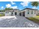 Stunning contemporary home with a paver driveway and a three-car garage, under a beautiful blue sky at 11921 Fort King Hwy, Thonotosassa, FL 33592