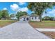 Beautiful home with a long paver driveway, lush green lawn, and mature trees on a sunny day at 11921 Fort King Hwy, Thonotosassa, FL 33592