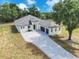 View of the property showcasing the driveway leading up to the stylish home with a three-car garage at 11921 Fort King Hwy, Thonotosassa, FL 33592