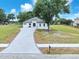 Stylish new construction home with a large driveway and modern landscaping on a sunny day at 11921 Fort King Hwy, Thonotosassa, FL 33592